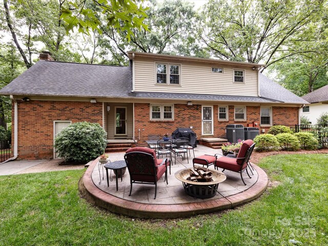 6941 Queensberry Dr, Charlotte, NC 28226 - back of property with a fire pit, brick siding, a patio area, a chimney, and a shingled roof