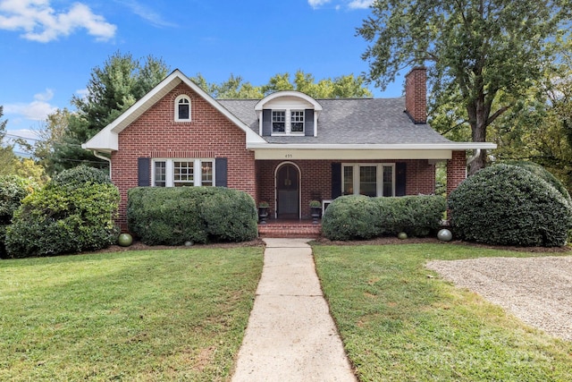 495 Fairview Rd, Asheville, NC 28803 - view of front facade featuring a chimney, brick siding, a front yard, and a porch
