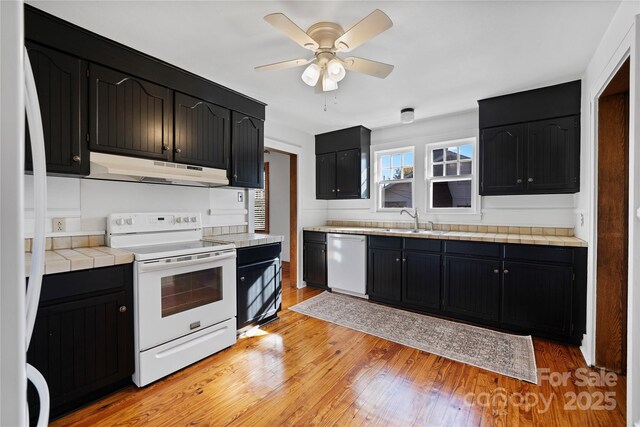 495 Fairview Rd, Asheville, NC 28803 - kitchen with white appliances, under cabinet range hood, dark cabinets, a sink, and ceiling fan