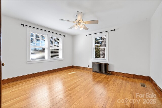 495 Fairview Rd, Asheville, NC 28803 - empty room with radiator, plenty of natural light, light wood-style flooring, and ceiling fan