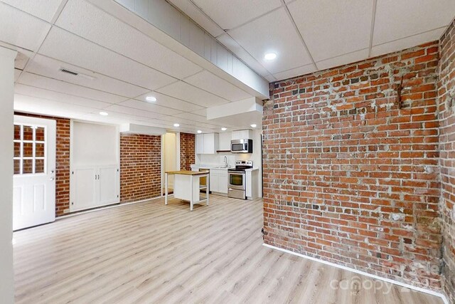 495 Fairview Rd, Asheville, NC 28803 - unfurnished living room featuring a paneled ceiling, brick wall, light wood finished floors, a sink, and recessed lighting