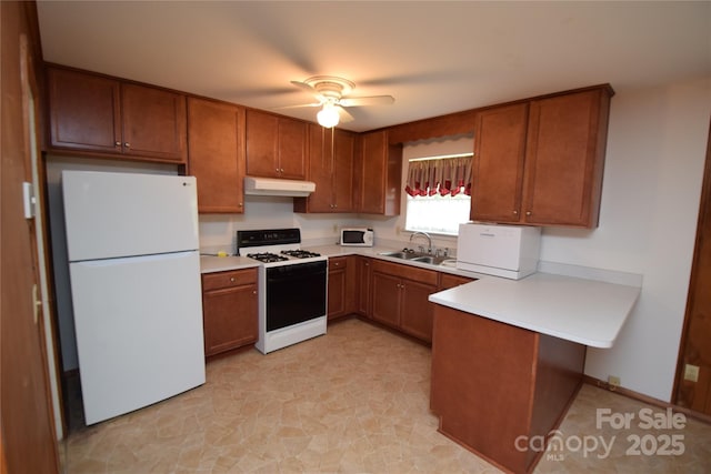 908 Ravendale Dr, Charlotte, NC 28216 - kitchen with white appliances, a sink, a peninsula, light countertops, and brown cabinetry