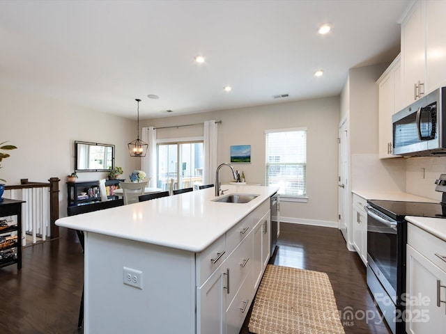 1839 Shumard Ln, Charlotte, NC 28205 - kitchen featuring appliances with stainless steel finishes, plenty of natural light, light countertops, a center island with sink, and recessed lighting