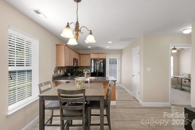 1907 Sandal Brook Rd, Fort Mill, SC 29707 - kitchen featuring black appliances, a chandelier, light wood-style floors, light brown cabinetry, and tasteful backsplash