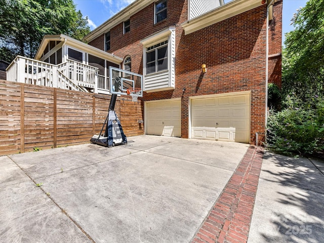 8218 Houston Ridge Rd, Charlotte, NC 28277 - back of property featuring a sunroom, brick siding, concrete driveway, and a garage