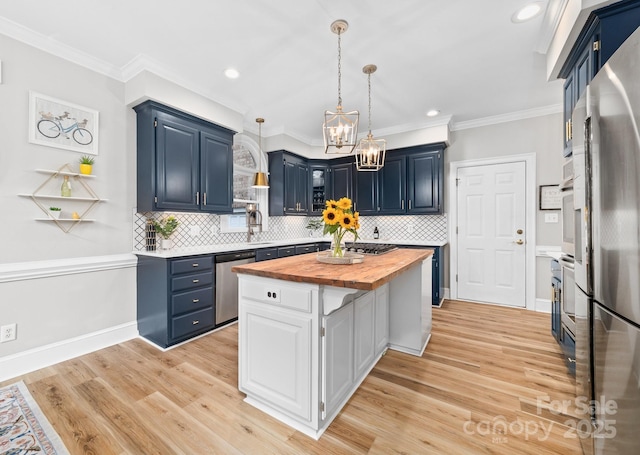 1115 Maremont Ct, Matthews, NC 28104 - kitchen featuring butcher block countertops, a center island, blue cabinets, stainless steel appliances, and crown molding
