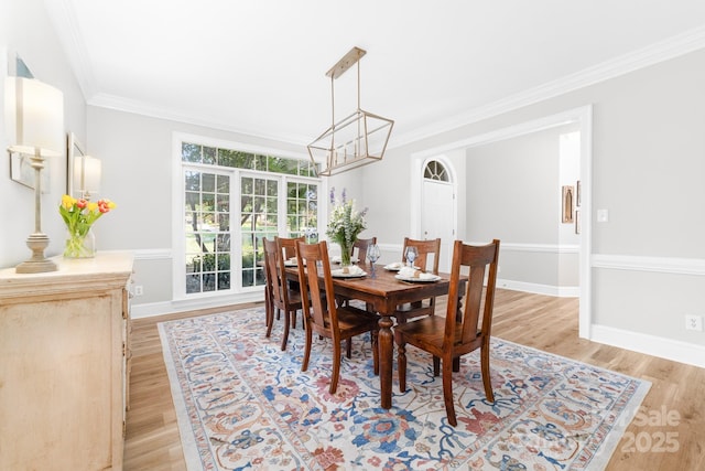 1115 Maremont Ct, Matthews, NC 28104 - dining room featuring light wood-style floors, a chandelier, crown molding, and baseboards