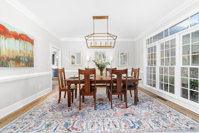 1115 Maremont Ct, Matthews, NC 28104 - dining space featuring crown molding, wood finished floors, baseboards, and a chandelier