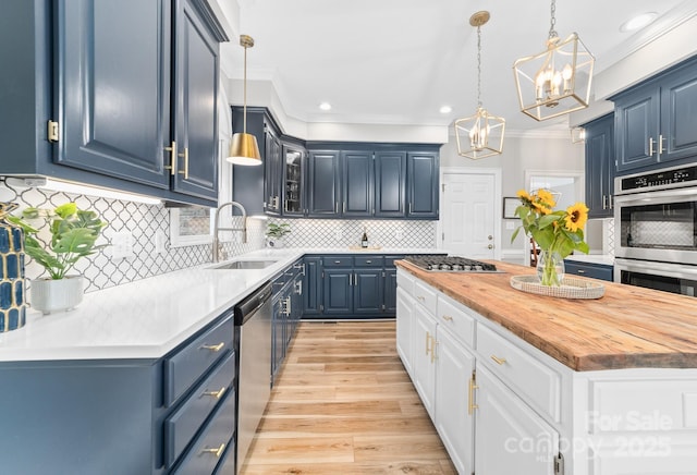 1115 Maremont Ct, Matthews, NC 28104 - kitchen featuring a sink, appliances with stainless steel finishes, crown molding, blue cabinets, and a chandelier