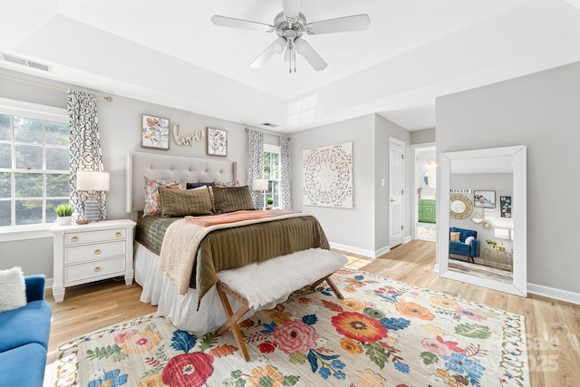 1115 Maremont Ct, Matthews, NC 28104 - bedroom featuring light wood-style floors, multiple windows, baseboards, and a raised ceiling