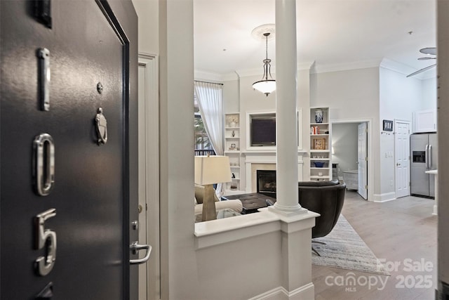 718 W Trade St Unit 105, Charlotte, NC 28202 - living room with crown molding, a fireplace, light wood-type flooring, and built in shelves