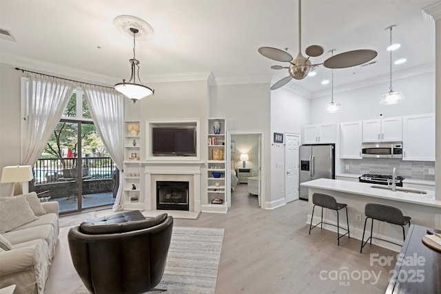 718 W Trade St Unit 105, Charlotte, NC 28202 - living room with a ceiling fan, ornamental molding, light wood-style floors, recessed lighting, and a fireplace with raised hearth