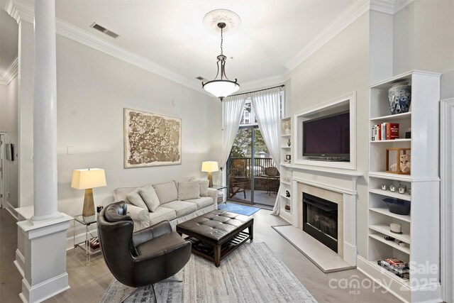 718 W Trade St Unit 105, Charlotte, NC 28202 - living area featuring decorative columns, ornamental molding, wood finished floors, built in shelves, and a high end fireplace