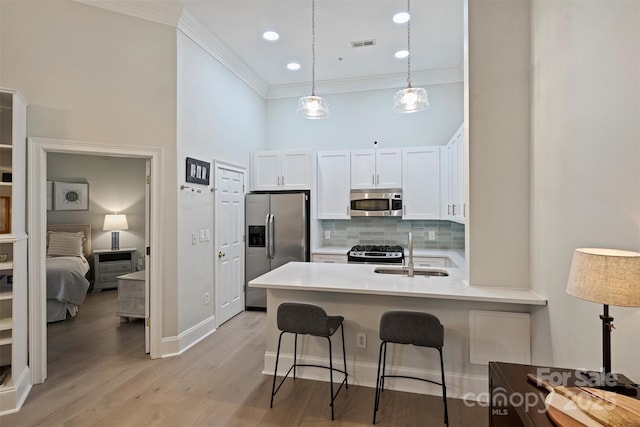 718 W Trade St Unit 105, Charlotte, NC 28202 - kitchen featuring stainless steel appliances, ornamental molding, white cabinetry, a peninsula, and tasteful backsplash