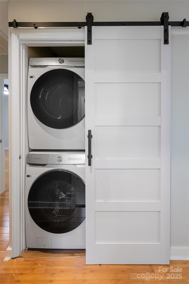 110 Annandale Ave, Asheville, NC 28801 - washroom with a barn door, estacked washer and dryer, and light wood-type flooring