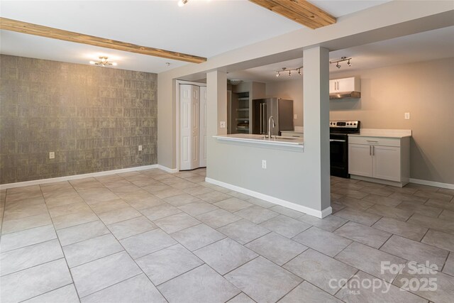 110 Annandale Ave, Asheville, NC 28801 - unfurnished living room featuring an accent wall, rail lighting, light tile patterned flooring, baseboards, and beamed ceiling
