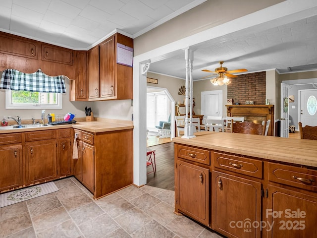 321 Jim Dobbins Rd, Rutherfordton, NC 28139 - kitchen with crown molding, a sink, light countertops, a ceiling fan, and brown cabinets