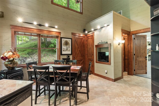 1283 Leafstone Cir, Sylva, NC 28779 - dining room with a towering ceiling, wood walls, and light tile patterned floors