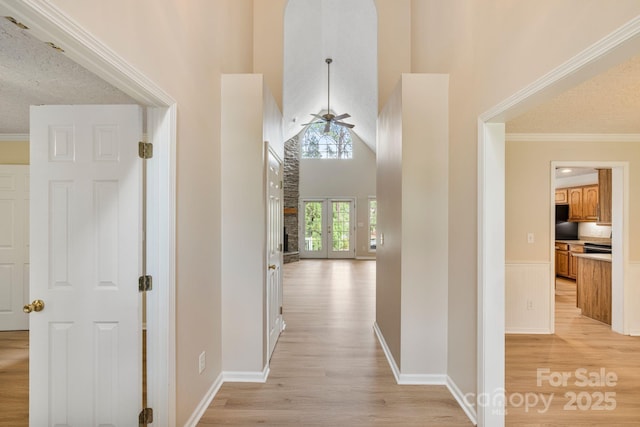 9372 Island Point Rd, Sherrills Ford, NC 28673 - hallway featuring light wood-style flooring, a high ceiling, crown molding, and wainscoting