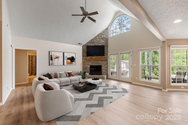 9372 Island Point Rd, Sherrills Ford, NC 28673 - living room featuring a textured ceiling, ceiling fan, a stone fireplace, healthy amount of natural light, and wood finished floors