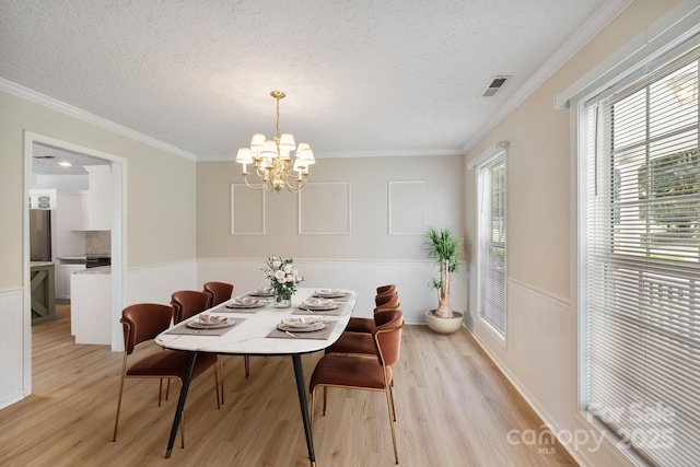 9372 Island Point Rd, Sherrills Ford, NC 28673 - dining room with light wood-type flooring, a textured ceiling, a wainscoted wall, a chandelier, and ornamental molding