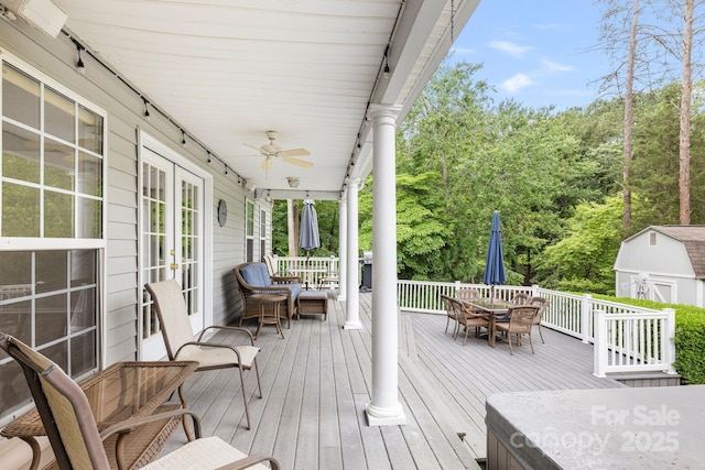 9372 Island Point Rd, Sherrills Ford, NC 28673 - wooden terrace featuring outdoor dining area, french doors, a ceiling fan, a storage unit, and view of scattered trees