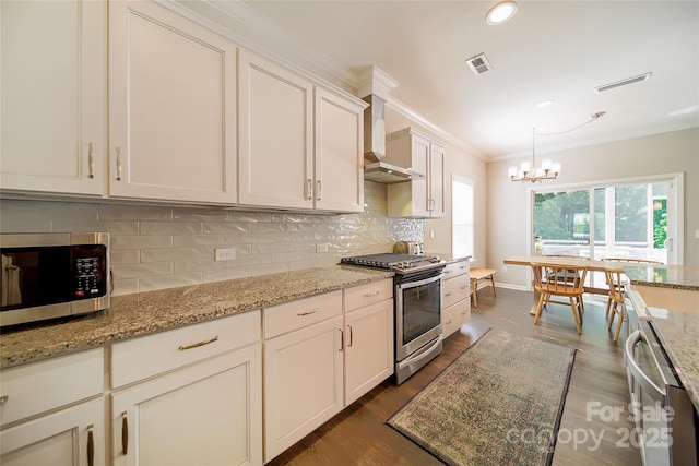 2035 Beacon Ave, Monroe, NC 28110 - kitchen featuring stainless steel appliances, wall chimney range hood, dark wood-style floors, decorative backsplash, and ornamental molding