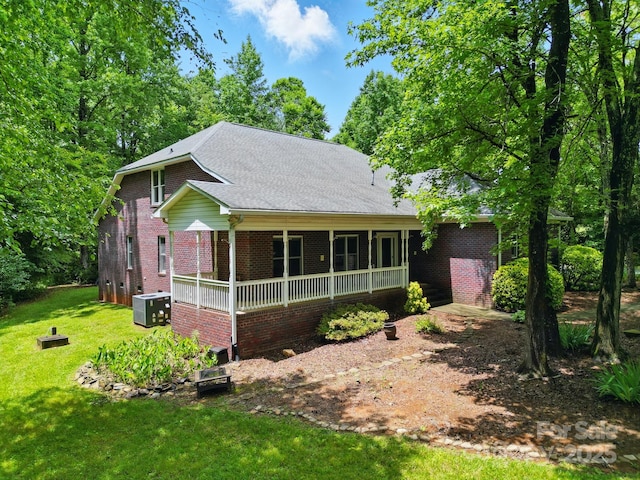 7725 Whitmire Ln, Mint Hill, NC 28227 - view of front facade featuring brick siding, a front yard, a porch, and central air condition unit