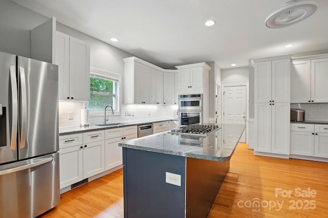 7725 Whitmire Ln, Mint Hill, NC 28227 - kitchen featuring stainless steel appliances, a sink, decorative backsplash, a kitchen island, and dark stone counters