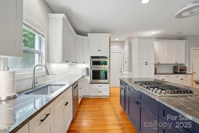 7725 Whitmire Ln, Mint Hill, NC 28227 - kitchen with stainless steel appliances, a sink, white cabinets, recessed lighting, and light wood-style flooring
