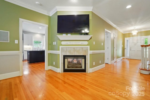 7725 Whitmire Ln, Mint Hill, NC 28227 - unfurnished living room with wood finished floors, crown molding, a chandelier, a sink, and a tile fireplace