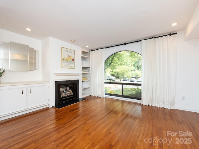 5809 Sharon Rd Unit G, Charlotte, NC 28210 - unfurnished living room with light wood-style floors, a fireplace with raised hearth, and recessed lighting