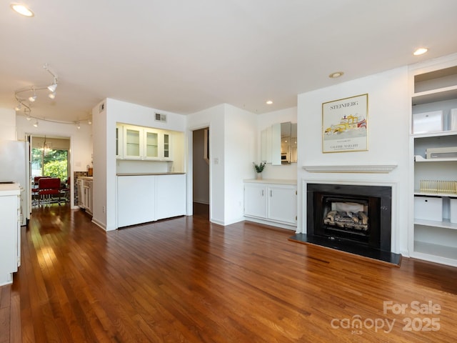 5809 Sharon Rd Unit G, Charlotte, NC 28210 - unfurnished living room featuring a fireplace with raised hearth, dark wood-style floors, and recessed lighting
