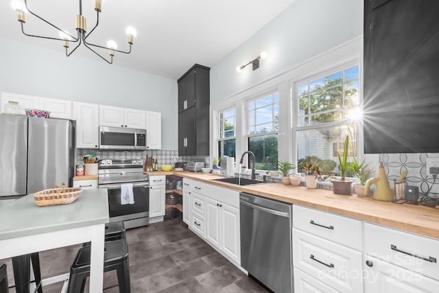 606 1st St W, Conover, NC 28613 - kitchen featuring appliances with stainless steel finishes, wood counters, a sink, a chandelier, and tasteful backsplash