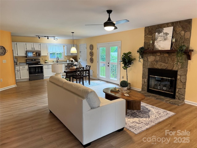 1228 Hidden Creek Cir, Hickory, NC 28602 - living area featuring wood finished floors, healthy amount of natural light, a stone fireplace, and a ceiling fan