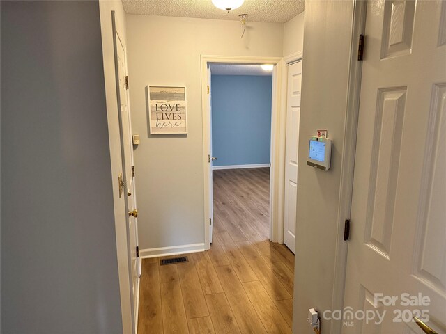 1228 Hidden Creek Cir, Hickory, NC 28602 - hallway with light wood-type flooring, a textured ceiling, and baseboards