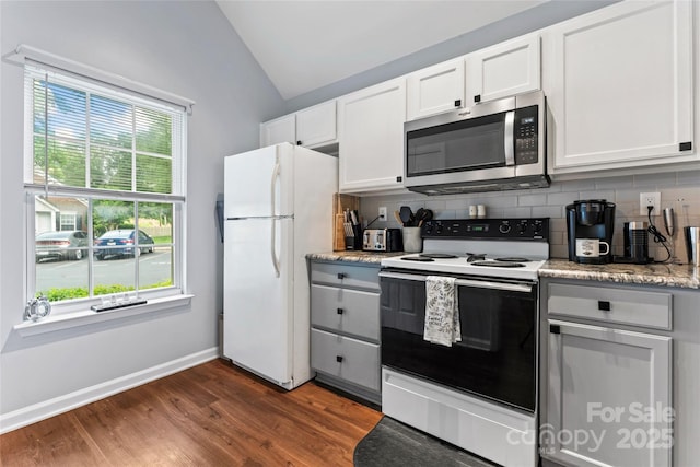 945 Heritage Pkwy, Fort Mill, SC 29715 - kitchen featuring white appliances, lofted ceiling, tasteful backsplash, dark wood-type flooring, and baseboards