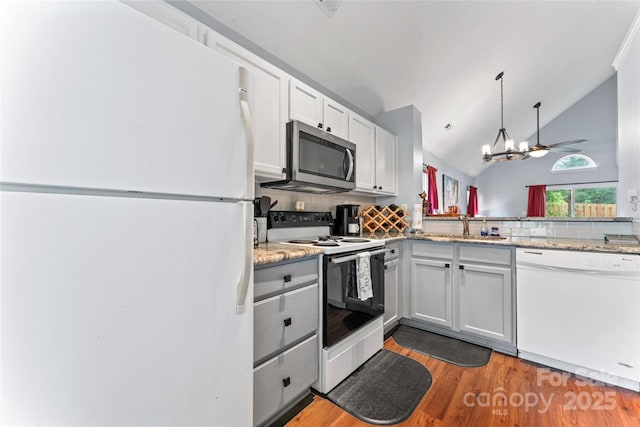 945 Heritage Pkwy, Fort Mill, SC 29715 - kitchen with white appliances, tasteful backsplash, a sink, light wood-style floors, and vaulted ceiling