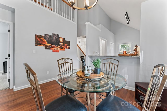 945 Heritage Pkwy, Fort Mill, SC 29715 - dining area featuring wood finished floors, high vaulted ceiling, baseboards, stairway, and a chandelier