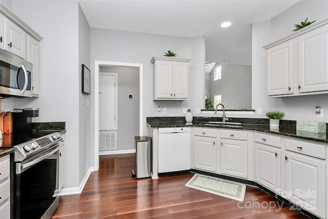 10449 Quiet Bay Ct, Charlotte, NC 28278 - kitchen with stainless steel appliances, dark wood-style flooring, a sink, recessed lighting, and white cabinets