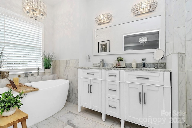 10449 Quiet Bay Ct, Charlotte, NC 28278 - full bathroom with a chandelier, marble finish floors, double vanity, a freestanding tub, and tile walls