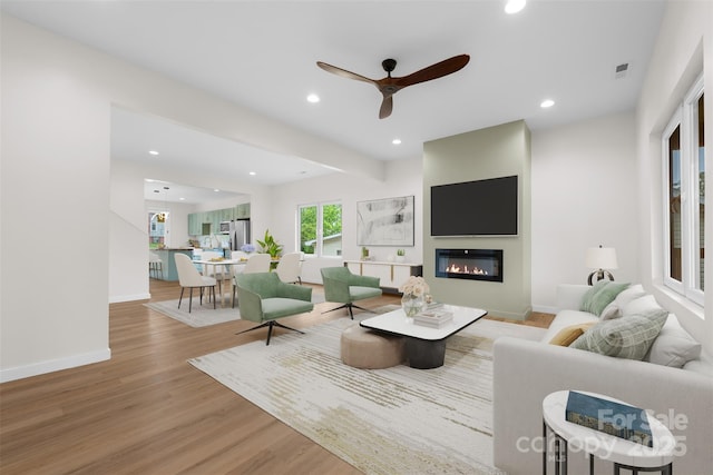 1076 W Henderson St, Marion, NC 28752 - living area with light wood finished floors, ceiling fan, recessed lighting, a glass covered fireplace, and baseboards