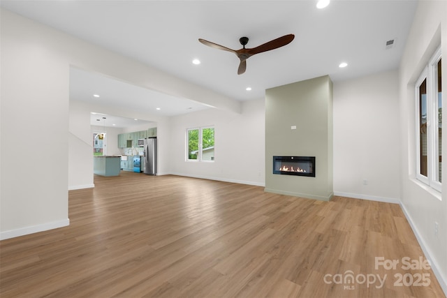 1076 W Henderson St, Marion, NC 28752 - unfurnished living room featuring light wood finished floors, a ceiling fan, a glass covered fireplace, recessed lighting, and baseboards