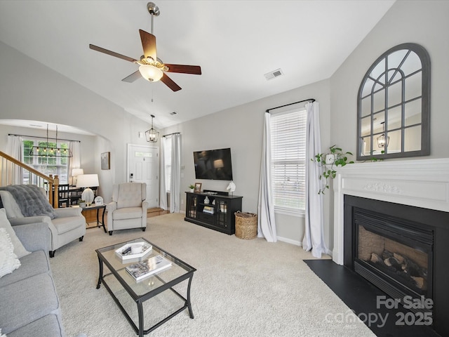 1061 Woodglen Ln, Matthews, NC 28104 - living area with lofted ceiling, arched walkways, carpet floors, a fireplace with flush hearth, and a ceiling fan
