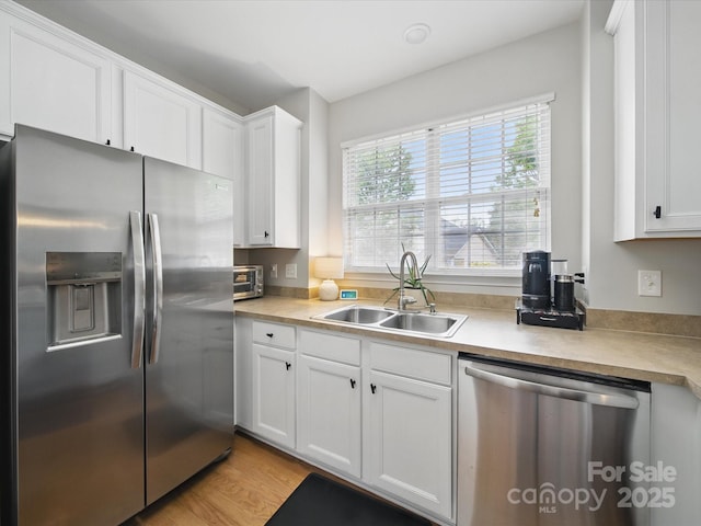 1061 Woodglen Ln, Matthews, NC 28104 - kitchen with stainless steel appliances, a sink, white cabinetry, and light countertops
