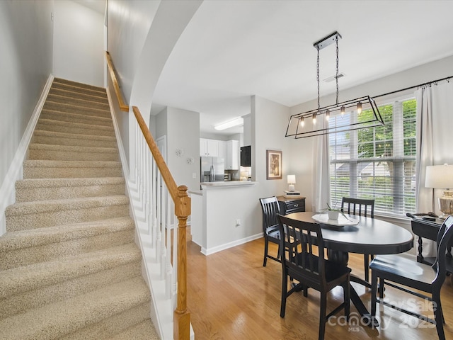 1061 Woodglen Ln, Matthews, NC 28104 - dining space featuring stairs, light wood-style floors, and baseboards