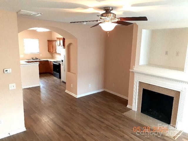 13441 Calloway Glen Dr, Charlotte, NC 28273 - unfurnished living room featuring arched walkways, ceiling fan, dark wood-type flooring, and a fireplace