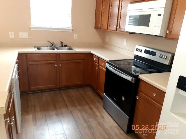 13441 Calloway Glen Dr, Charlotte, NC 28273 - kitchen featuring stainless steel electric range oven, white microwave, a sink, wood finished floors, and brown cabinets