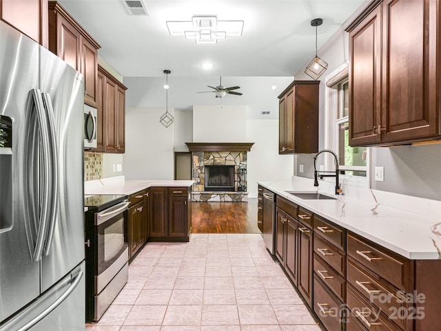 110 Village Pointe Ln, Asheville, NC 28803 - kitchen with appliances with stainless steel finishes, a ceiling fan, a fireplace, and hanging light fixtures