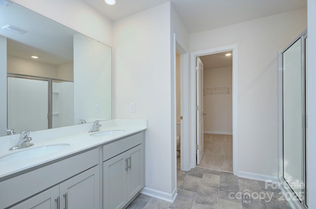 427 Carolina Hemlock Dr, Locust, NC 28097 - full bathroom featuring a shower stall, baseboards, double vanity, toilet, and a spacious closet